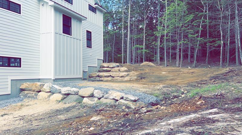 Boulder retaining wall in a Maine landscape
