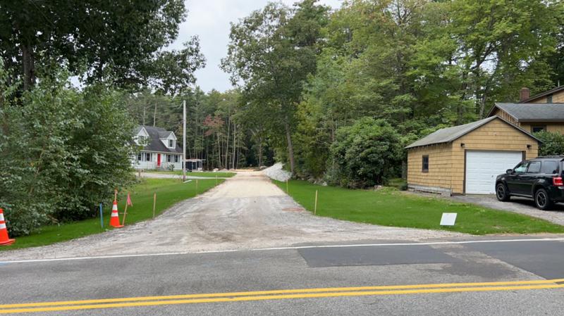 Excavator shaping a residential driveway