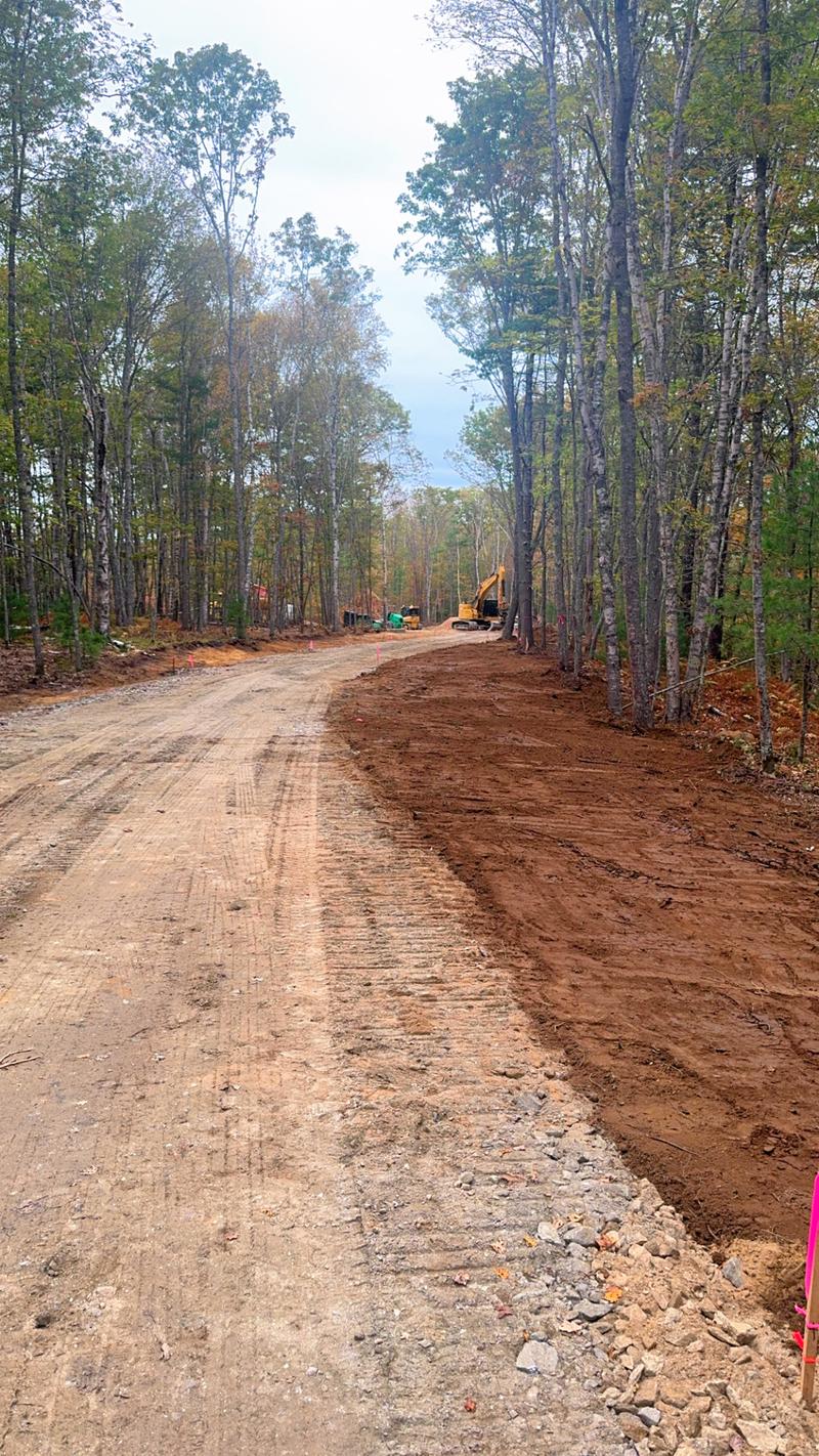 Excavator shaping a residential driveway