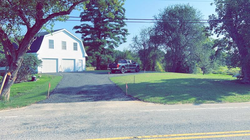 Excavator shaping a residential driveway