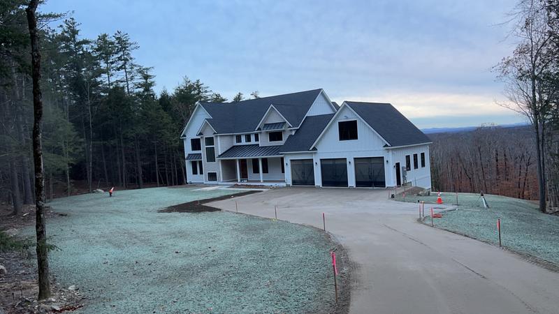 Excavator shaping a residential driveway